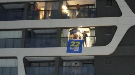 Re: Lula em Salvador: Diego Castro pendura bandeira de Flávio Bolsonaro durante caminhada do PT na Orla
